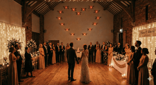 Drones con luz formando un corazón mientras los novios de una boda e invitados miran el espectáculo